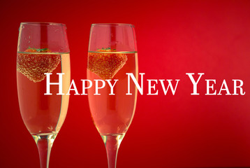 Happy new year against two glasses of champagne with strawberries