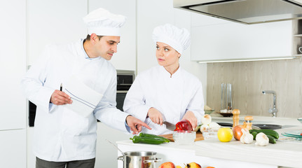 Portrait of the woman proffesional who is posing with devices in the kitchen