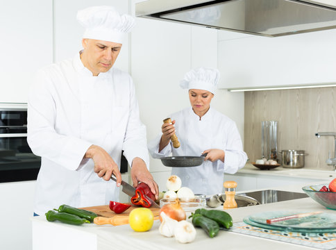 Portrait of the woman proffesional who is posing with devices in the kitchen