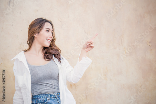 Portrait Of Young Beautiful Asian Woman Sit With Her Finger Point