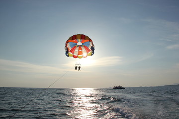 A man and a girl are flying on a parachute.