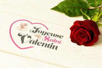 Valentines message against red rose on wood