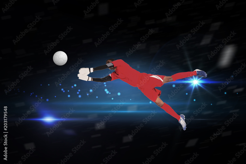 Fototapete goalkeeper in red making a save against black background with spark