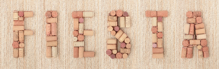 Word FIESTA  made of wine corks on jute rope background. Banner