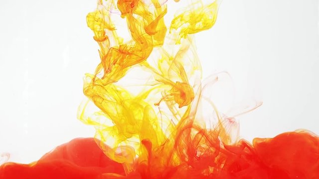 Acrylic ink moving in water on white background. Red and yellow paint swirling in water creating abstract clouds. 60fps, HD format. Traces of colourful ink dissolving in water, ever changing shape.