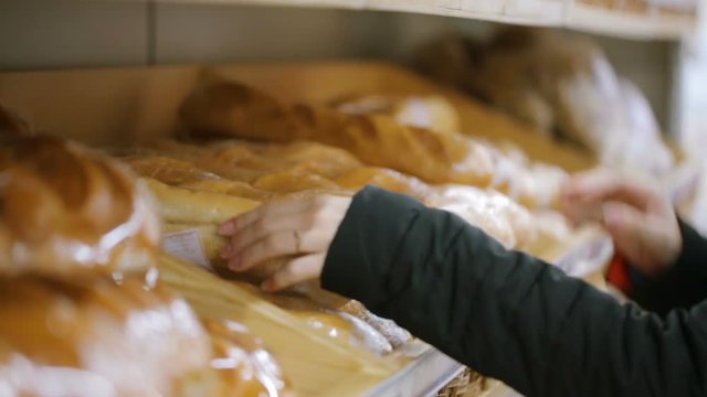 Woman choosing bread at shop
