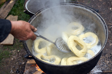 Old woman boiling homemade bagels