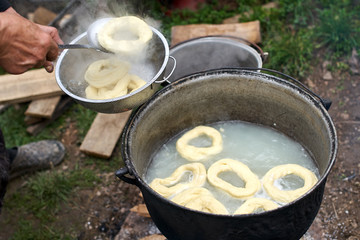 Old woman boiling homemade bagels