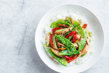 stir fry chicken and vegetables with rice in white bowl