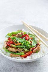 stir fry chicken and vegetables with rice in white bowl