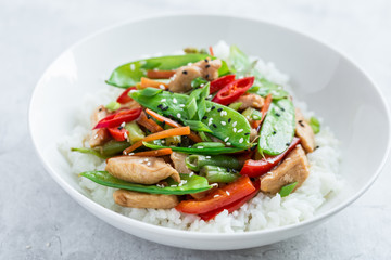 stir fry chicken and vegetables with rice in white bowl