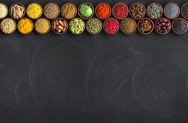 Indian spices on black table background. chalkboard for food with condiments