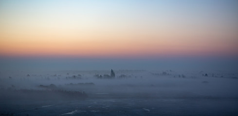 View towards Kalvebod Faelled, the airport and Amager from Oerestad early in the morning. Fog rising from the ground makes this a dreamy scene.