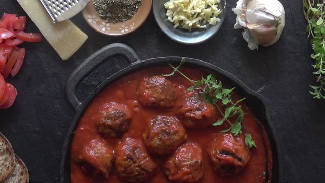 Meatballs cooked in a Cast Iron Pan on a dark background.