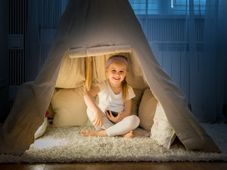 Little girl in teepee tent in room © tan4ikk