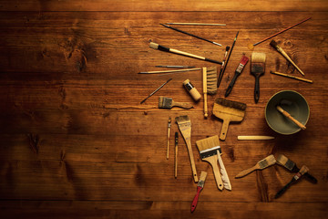 painting still life with lot of type brushes and other tools on a wooden background