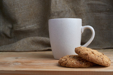 Oatmeal cookies with sunflower seeds near cup of tea.