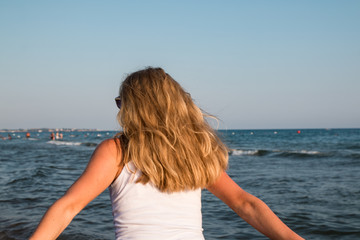 Blond teenager girl on the beach near sea