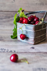 organic cherries freshly picked in a metal box on wooden background 