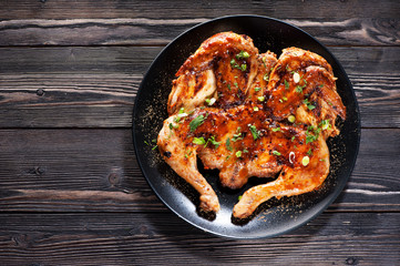 Grilled fried roast Chicken Tabaka on a plate on a wooden background, top view - obrazy, fototapety, plakaty
