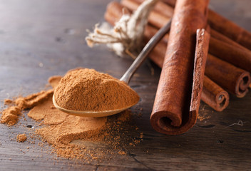 Cinnamon sticks and powder in small spoon.