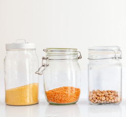 Set of cereals in a glass jar on a white background, chickpeas lute and millet, healthy diet and diet concept