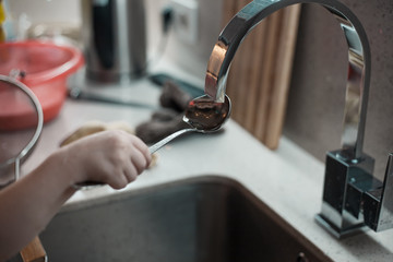 Little girl helps dad in a beautiful kitchen to cook food and wash dishes