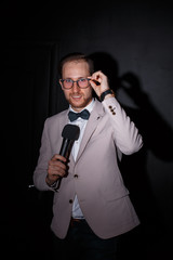 Naklejka premium Young man with microphone on white background, leading with microphone