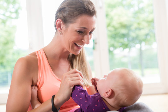 Happy Mom And Newborn Baby Playing Together In Baby Course