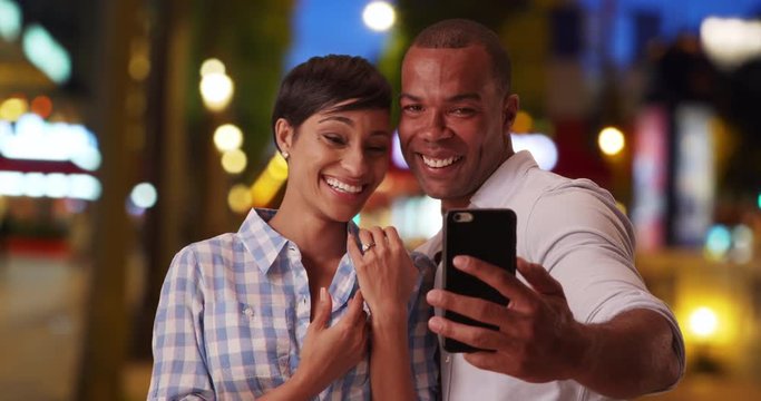 Happy African-American couple facetime someone to tell about their recent engagement, Black female expresses joy after accepting her boyfriends proposal during a video chat on his phone, 4k