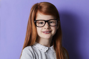 Fototapeta premium Happy redheaded girl in glasses, portrait