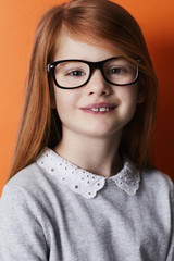 Fototapeta premium Confident kid in spectacles with red hair, portrait