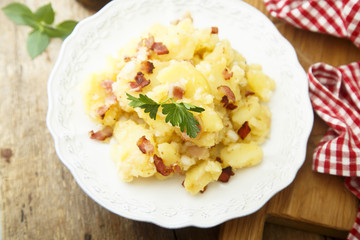 Potato salad with fried bacon and parsley