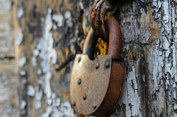 Rusty old lock on the wooden doors.