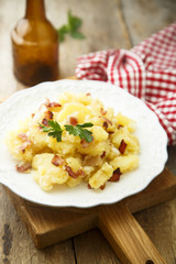Potato salad with fried bacon and parsley