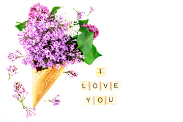 Flowers composition. Lilac in waffle cone on white background. Flat lay, top view, copy space. Concept of proposal, love and tenderness.
