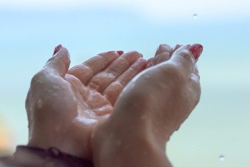 Rain drops falling on woman’s hand 