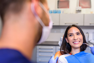 A young Dentist treating a female Patient in the dental studio