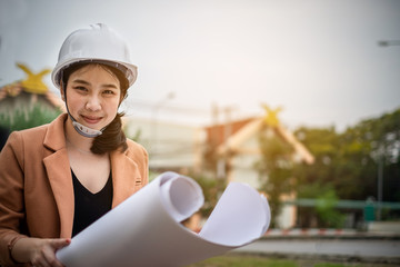 Architect woman working with blueprints for architectural at construction site. plan,engineer sketching a construction project concept.