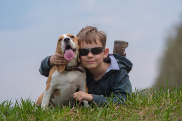 European boy with Beagle dog lying on grass