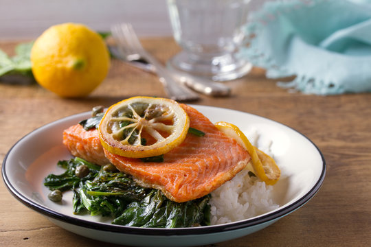 Salmon fillet with rice, spinach and lemon. Salmon with garnish. Fish for healthy dinner