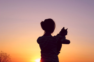 People,Freedom,Pet, Travel,Abstract Concept.Silhouette Of A Young Girl Holding A Cat At Sunset,Cropped Shot.Shot Of A Carefree Girl At The Beach Against The Sunset.Goodbye Sunlight.
