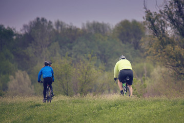 Fototapeta premium woman and man riding bicycles in the natural environment