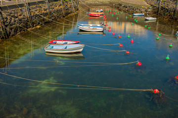 small blue and red fishing boats, shallow water in docks 