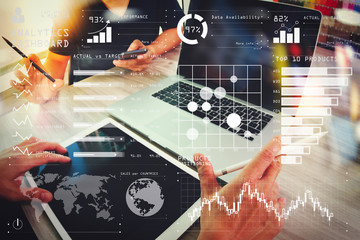 two colleagues interior designer discussing data and blank screen digital tablet and computer laptop with smart phone on wooden desk as concept