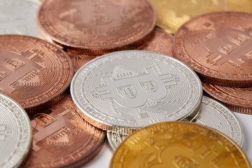 close-up shot shot of various bitcoins spilled on white surface