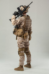 Soldier in camouflage holding rifle