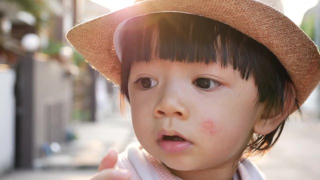 slow-motion, cute child eyes looking question around himself with beautiful soft sunlight scene