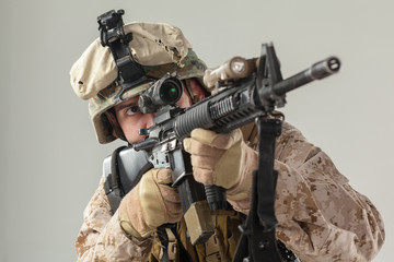 Soldier in camouflage holding rifle