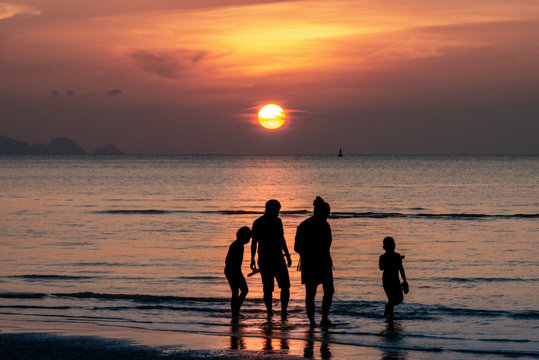 Sonnenuntergang im Meer mit Familie (Silhouette)
